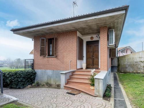 Casa de ladrillo con puerta de madera y escaleras en Holiday Home La Casa del Nonno by Interhome, en Montegrosso dʼAsti