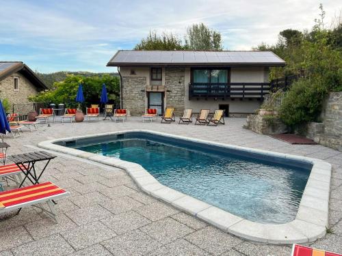 CortemiliaにあるApartment Quadrilocale 19 by Interhomeの椅子と家のあるプール