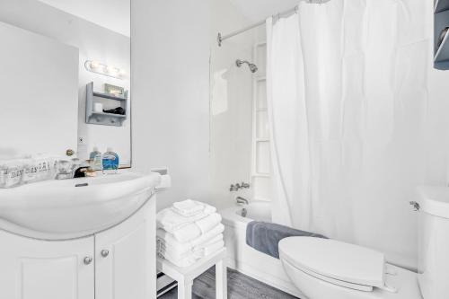 Baño blanco con lavabo y aseo en Cape View Motel & Cottages, en Mavillette