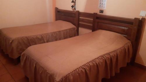 two beds with brown covers in a room at Cruz Popayan Sucre in Sucre