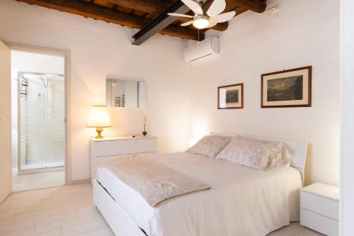 a white bedroom with a bed and a ceiling fan at AnticaValle Intero Appartamento in Verona