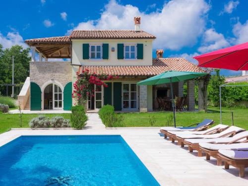 a villa with a swimming pool in front of a house at Villa Bella by Interhome in Marčana