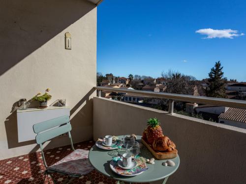 une table sur un balcon avec un tableastryasteryasteryasteryasteryasteryasteryasteryastery astery dans l'établissement Apartment Résidence les Roses by Interhome, à Lunel