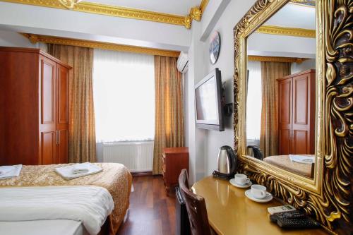 een hotelkamer met 2 bedden en een spiegel bij Californiacityhotel in Istanbul