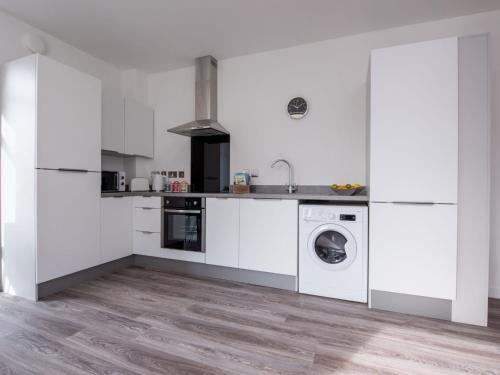 a kitchen with white cabinets and a washing machine at Studio Harbour Nights 12 Deluxe by Interhome in Lossiemouth