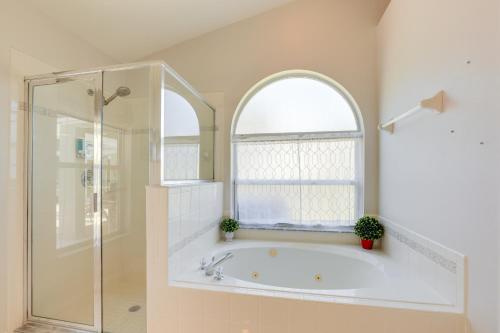 a bathroom with a bath tub and a window at Jensen Beach Home with Heated Pool! in Jensen Beach