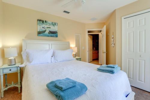 a bedroom with a white bed with two towels on it at Jensen Beach Home with Heated Pool! in Jensen Beach