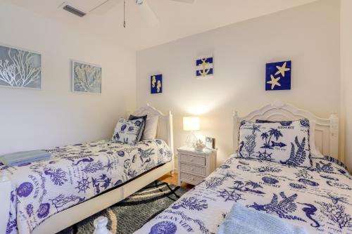 a bedroom with two beds with blue and white sheets at Jensen Beach Home with Heated Pool! in Jensen Beach