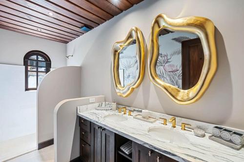un bagno con due lavandini e due specchi di Trendy Condo with Modern Decor, Stunning Ocean Views, and Exclusive Beach Club Access a Playa Danta