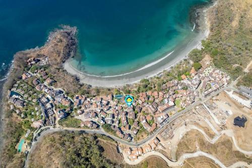 an aerial view of a village next to a lake at Trendy Condo with Modern Decor, Stunning Ocean Views, and Exclusive Beach Club Access in Playa Danta