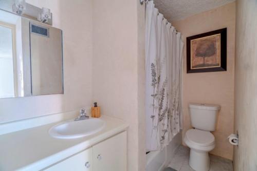 a white bathroom with a toilet and a sink at Budget-Friendly Haven- Comfort & Convenience in San Juan