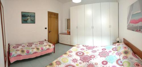ガリポリにあるLa Spiaggia sotto Casaのベッドルーム1室(ベッド2台、白いキャビネット付)