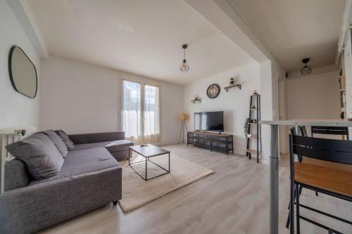 un salon avec un canapé et une télévision dans l'établissement Trioasis - 3 chambres, à Reims