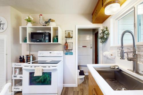 a kitchen with a white stove and a sink at Bella Bella Beach Cottage in Gig Harbor