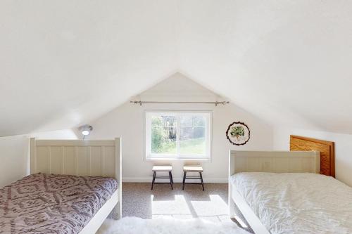 a bedroom with two beds and a window at Bella Bella Beach Cottage in Gig Harbor
