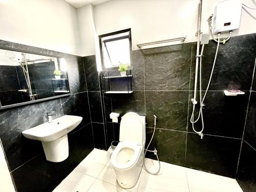 a bathroom with a toilet and a sink at Sierra Bay View Jacuzzi Overlooking Roofdeck in Binangonan