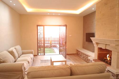 a living room with a couch and a fireplace at Dar Gerasa chalets - شاليهات دار جراسا in Jerash