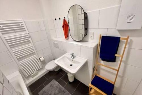a white bathroom with a sink and a mirror at Modern & Stilvoll mit Kino - Wii in Essen