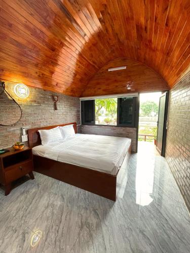 a bedroom with a large bed with a wooden ceiling at Hoa Lu Garden Resort in Ninh Binh