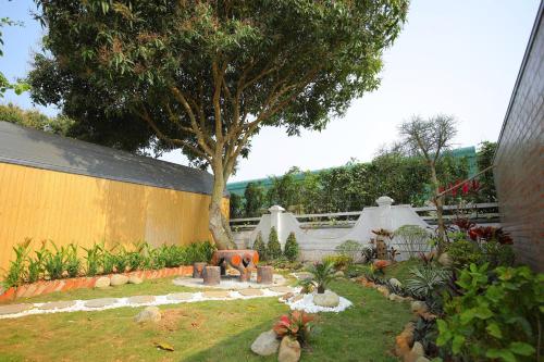 a garden with a tree and a fire place at Hoa Lu Garden Resort in Ninh Binh