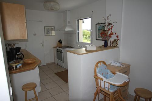 - une cuisine avec un comptoir et quelques chaises dans l'établissement Maison 8p sud bretagne 5km de la mer, à Saint-Molf