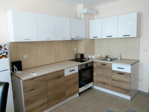 a small kitchen with white cabinets and a sink at My Beach Home Kranevo in Kranevo