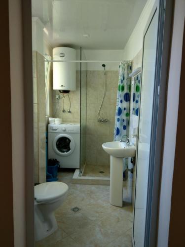 uma casa de banho com um lavatório e uma máquina de lavar roupa em My Beach Home Kranevo em Kranevo
