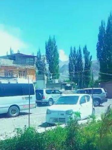 un grupo de autos estacionados en un estacionamiento en Baltistan Sarayee hotel £ Guest House, en Skardu