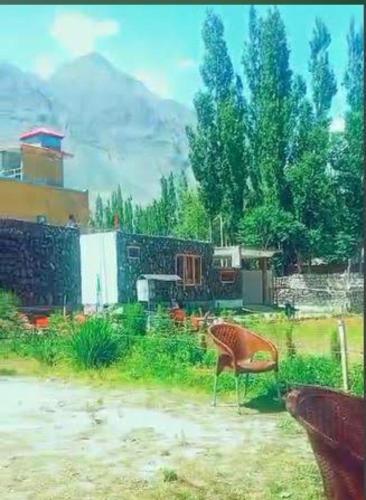 a chair sitting in the grass in a yard at Baltistan Sarayee hotel £ Guest House in Skardu