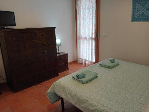 una camera da letto con un letto con due asciugamani verdi di Casa Helichrysum a Santa Margherita di Pula