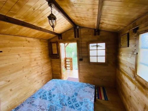 - une chambre avec un lit dans une pièce en bois dans l'établissement Camping Mala Clisura Dunării, à Eşelniţa