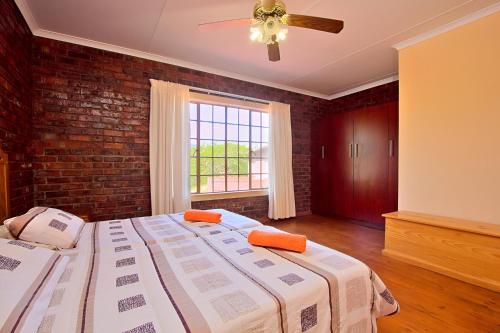 a bedroom with a large bed and a brick wall at Elangeni Holiday Resort in Waterval Boven