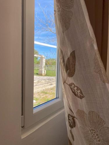 a window with a curtain in front of it at Agriturismo Tenuta la Monaca in Aradeo