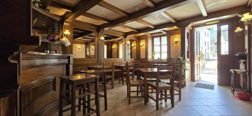 斯科佩洛的住宿－阿爾坎圖茲歐酒店，餐厅内带木桌椅的酒吧