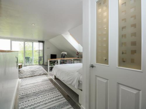 a white bedroom with a bed and a window at Abbey Cottage in Newball