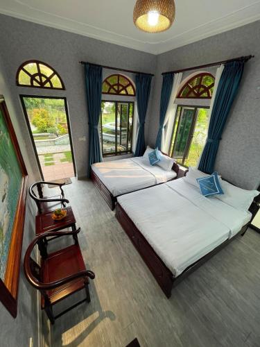 two beds in a room with two windows at Hoa Lu Garden Resort in Ninh Binh
