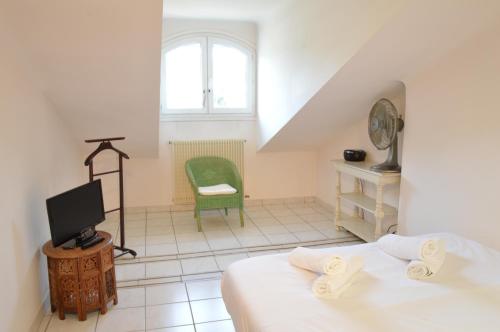 une chambre avec un lit, une télévision et une chaise dans l'établissement Appartement vue mer proches plages et congrès, à Cannes