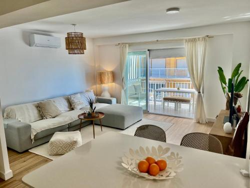 uma sala de estar com um sofá e uma mesa em Casa Oli,1 LINEA DE PLAYA, FAMILIAS Y PAREJAS em Playa de Gandia