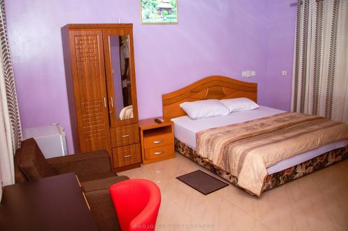 a bedroom with a bed and a table and a chair at NABTEL HOTEL in Spintex