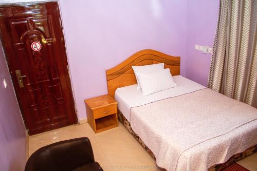 a small bedroom with a bed and a chair at NABTEL HOTEL in Spintex