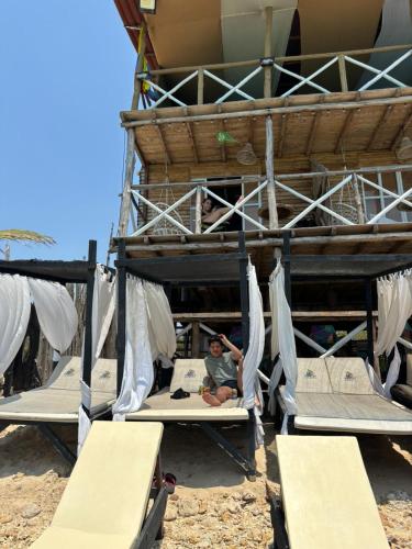 a man is sitting on a bed in a bunk bed at Tequila SunBeach Baru Eco-Hotel in Baru