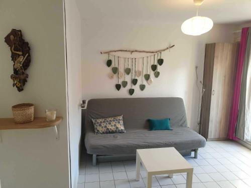 un salon avec un canapé et une table dans l'établissement Studio idéal séjour en amoureux rez de jardin proche plage, à Bormes-les-Mimosas