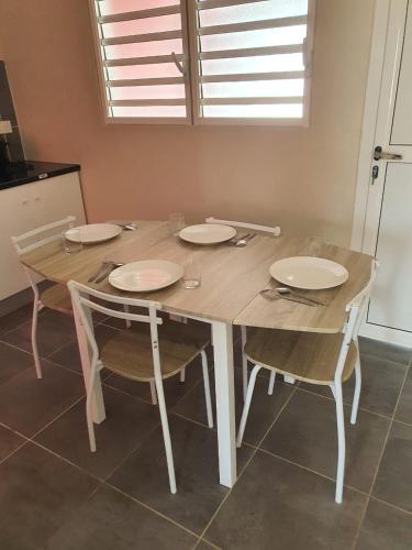 a dining room table with four chairs and a table at DEJANIRA IMMOBILIER in Saint-Laurent du Maroni