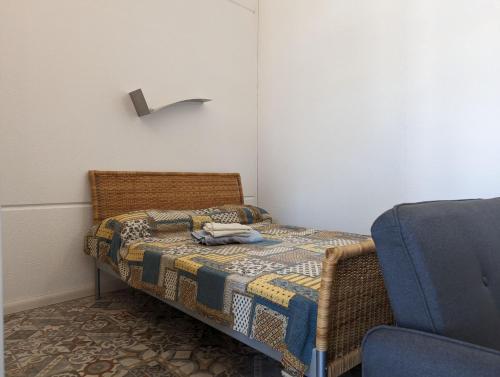 1 dormitorio pequeño con 1 cama y 1 silla en Monolocale Viale Arbatax en Tortolì