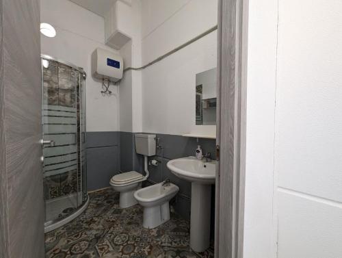een badkamer met een toilet, een wastafel en een douche bij Monolocale Viale Arbatax in Tortolì