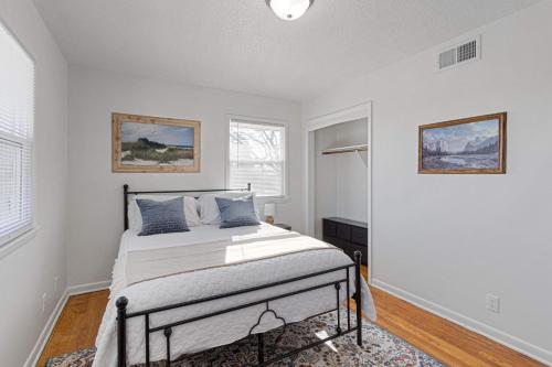 um quarto branco com uma cama com almofadas azuis em Nadia's Place em Omaha