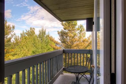 einen Balkon mit einem Tisch und Blick auf die Bäume in der Unterkunft Mountain Green Condos at Killington in Killington