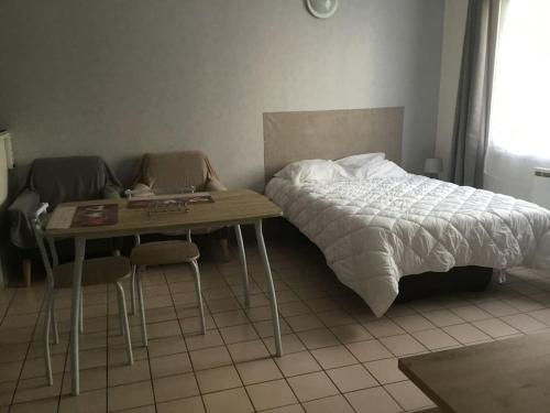une chambre avec un lit et une table avec un ordinateur portable dans l'établissement Studio meublé 27 mètres carrés wifi netflix, à Niort