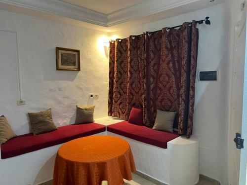 a room with two red benches and a table at Signature in Hammamet Sud