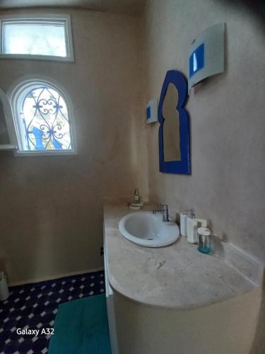 baño con lavabo y ventana en Villa La Palmeraie, en Oualidia